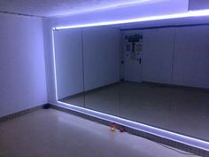 an empty room with mirrors and lights on the wall