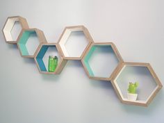 three hexagonal shelves with green vases on each shelf and one small potted plant in the middle