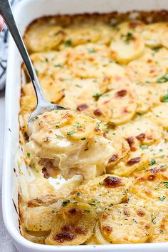 a casserole dish with potatoes and cheese being lifted by a ladler from the casserole