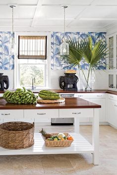 a kitchen with blue and white wallpaper, wooden counter tops and baskets on the island