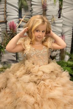 Make your little princess feel like a true royalty in the Aurelia Girls Satin Glitter Tulle Pageant Dress! This stunning gown features a ton of ruffles that will make her feel extra special, just like she deserves. The bodice is adorned with a beautiful pattern of sparkling sequins, a sheer neckline, and feathered sleeves, while the deep V neckline in the back adds a touch of elegance. The full length skirt is absolutely magnificent, with multiple layers of glitter and solid tulle that create a Gold Flower Girl Dress, Formal Flower Girl, Gold Flower Girl, Gray Flower Girl, Dress For Special Occasion, Girls Communion Dresses, Gold Tulle, Wedding Party Bridesmaid, Best Prom Dresses