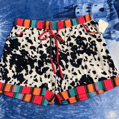 Southern Stitch Pocket Shorts Jersey Material. Cow Print Black And White With Serape Border On Waist And Leg Trim