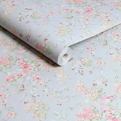 a blue floral wallpaper with pink and white flowers on the bottom half of it