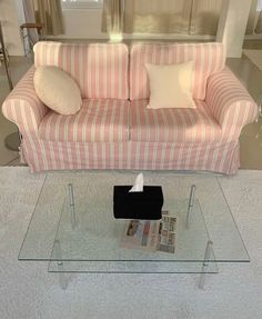 a living room with a striped couch and glass coffee table