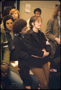 a group of people standing next to each other in front of a mirror with their arms crossed