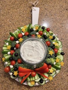 a wreath made out of cucumbers, tomatoes, broccoli and other vegetables