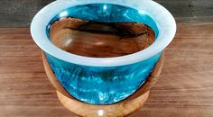 a blue and white glass vase sitting on top of a wooden table next to a wall