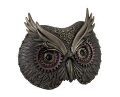 an owl statue with large eyes and ornate details on it's face, sitting in front of a white background