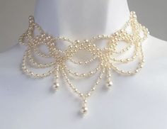 a white mannequin with pearls on it's neck and an elaborate necklace