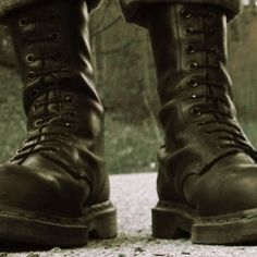 black and white photograph of someone's boots on the ground