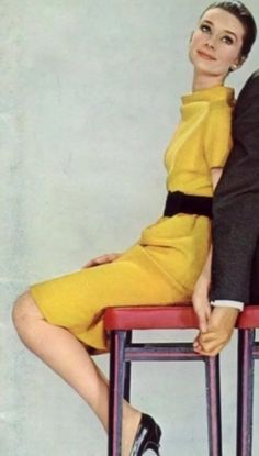 a woman sitting on top of a red chair next to a man