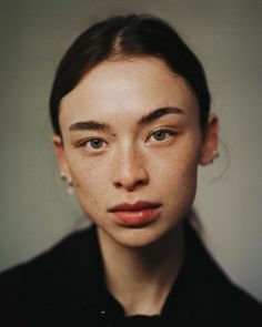 a woman with freckles on her face looking at the camera