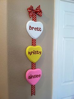 three heart shaped signs hanging on the side of a wall next to a white door