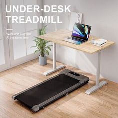 a desk with a laptop and treadmill on it