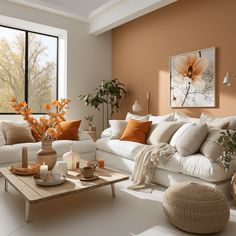 a living room filled with lots of white furniture and orange pillows on top of it