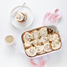 a white dish filled with food next to a cup of coffee