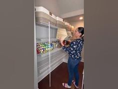 a woman standing in front of a shelf filled with food