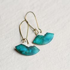 These amazing earrings have been made by enamelling geometric brass scallops in a opaque white, before adding fine layers of navy blue, teal, turquoise and sea green.  The pattern of the blue-green enamel has an amazing, fluid effect, with varying depth of colour and beautiful dappling across the pendant.  I have added a high quality solid brass earwires. The earrings are available in two lengths, both identical in appearance.  The shorter earring measures a total of 40mm long, and the enamelled Navy Earrings, Message Necklace, Engraved Locket, Acorn Necklace, Book Locket, Hand Painted Earrings, Fan Earrings, Jade Earrings, Bee Necklace