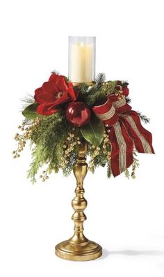 a gold candle holder with red flowers and greenery