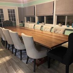 a large wooden table surrounded by white chairs