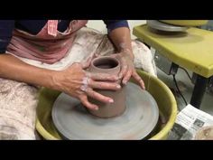 a woman is making a pot on a potter's wheel with her hands in it