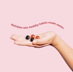 a woman's hand holding three balls with the words nutrition win healthy habit made easier