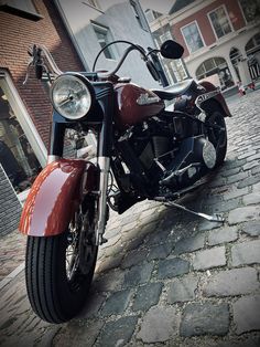 the motorcycle is parked on the cobblestone street