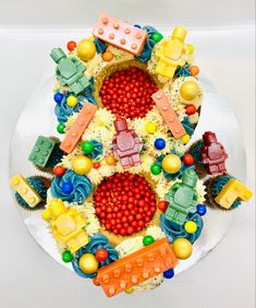 a white plate topped with lots of cupcakes covered in frosting and candies