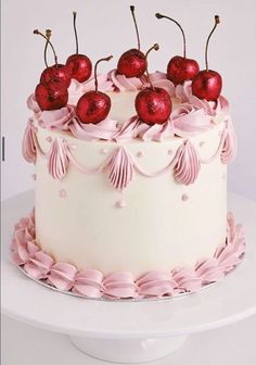 a white cake with pink icing and cherries on top