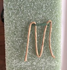 a pair of hair clips sitting on top of a green towel next to a wall