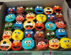 a box full of cupcakes decorated like sesame street characters