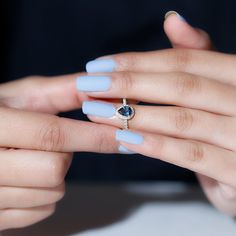 a woman's hands with blue manicures and a ring on her finger