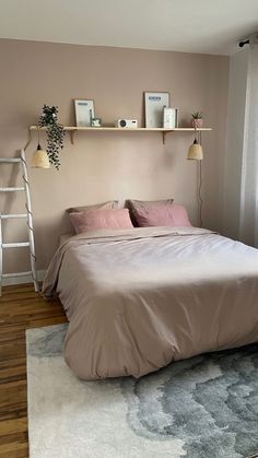 a bed sitting in a bedroom next to a window with white curtains and a ladder