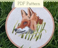 an embroidery pattern with a fox on it's face and grass in the background