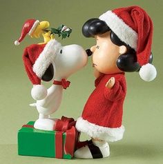 a charlie brown christmas figurine with santa hat and dog on top of it