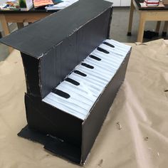 an open cardboard piano sitting on top of a table