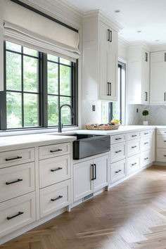 a large kitchen with white cabinets and black counter tops on the windowsills is seen in this image