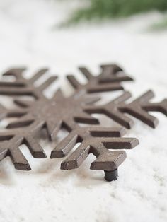 two snowflakes sitting on top of a white surface