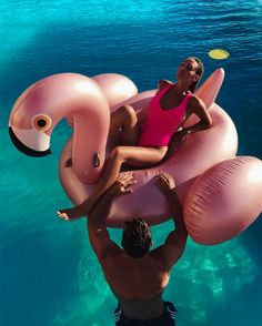 a man and woman are floating on an inflatable flamingo pool floatie