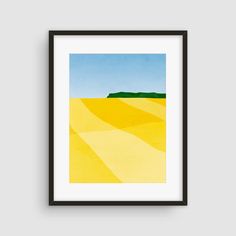 a yellow field with blue sky and green hills in the background, framed in black frame