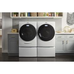 the front load washer and dryer are sitting side by side in this kitchen