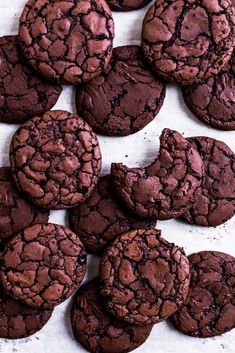 chocolate cookies are arranged on a white surface with crumbs all over the edges