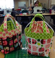 two purses sitting on top of a table next to each other in front of a laptop computer