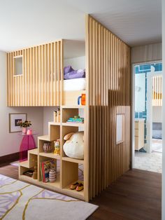 a child's room with bunk beds and bookshelves