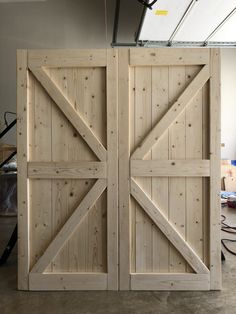 two wooden doors are open in a room with construction materials on the floor behind them