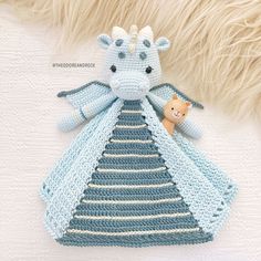 a crocheted baby blanket with a stuffed animal