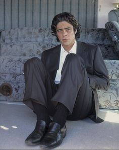 a man in a suit and tie sitting on the ground