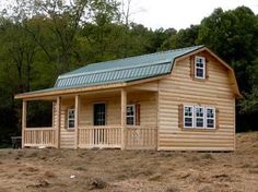 a small log cabin with a green roof