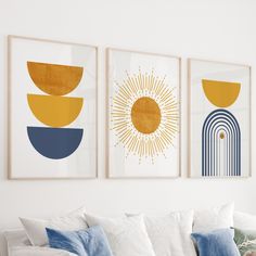 three art prints hanging on the wall above a couch