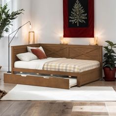 a bed that is sitting in the middle of a room next to a rug and potted plants